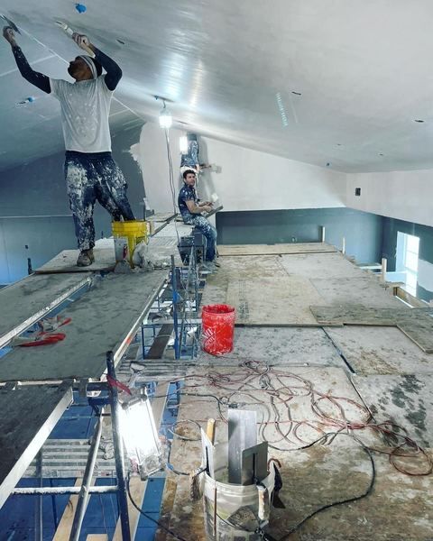 SUR crew taping a ceiling from scaffolding
